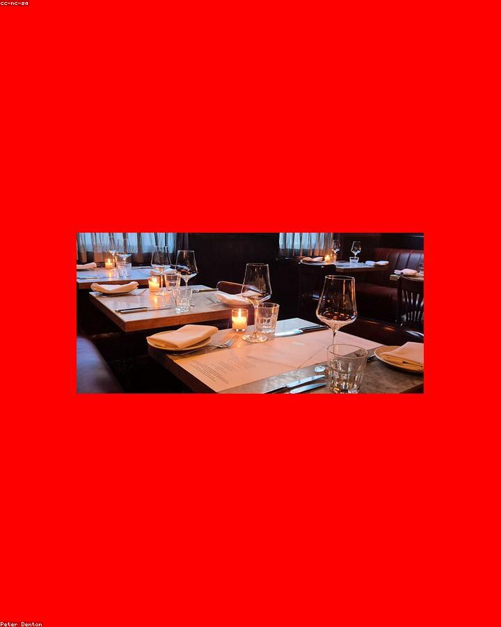 La sala della Trattoria al Campanile a San Feliciano, tavoli apparecchiati con vista sulla piazza